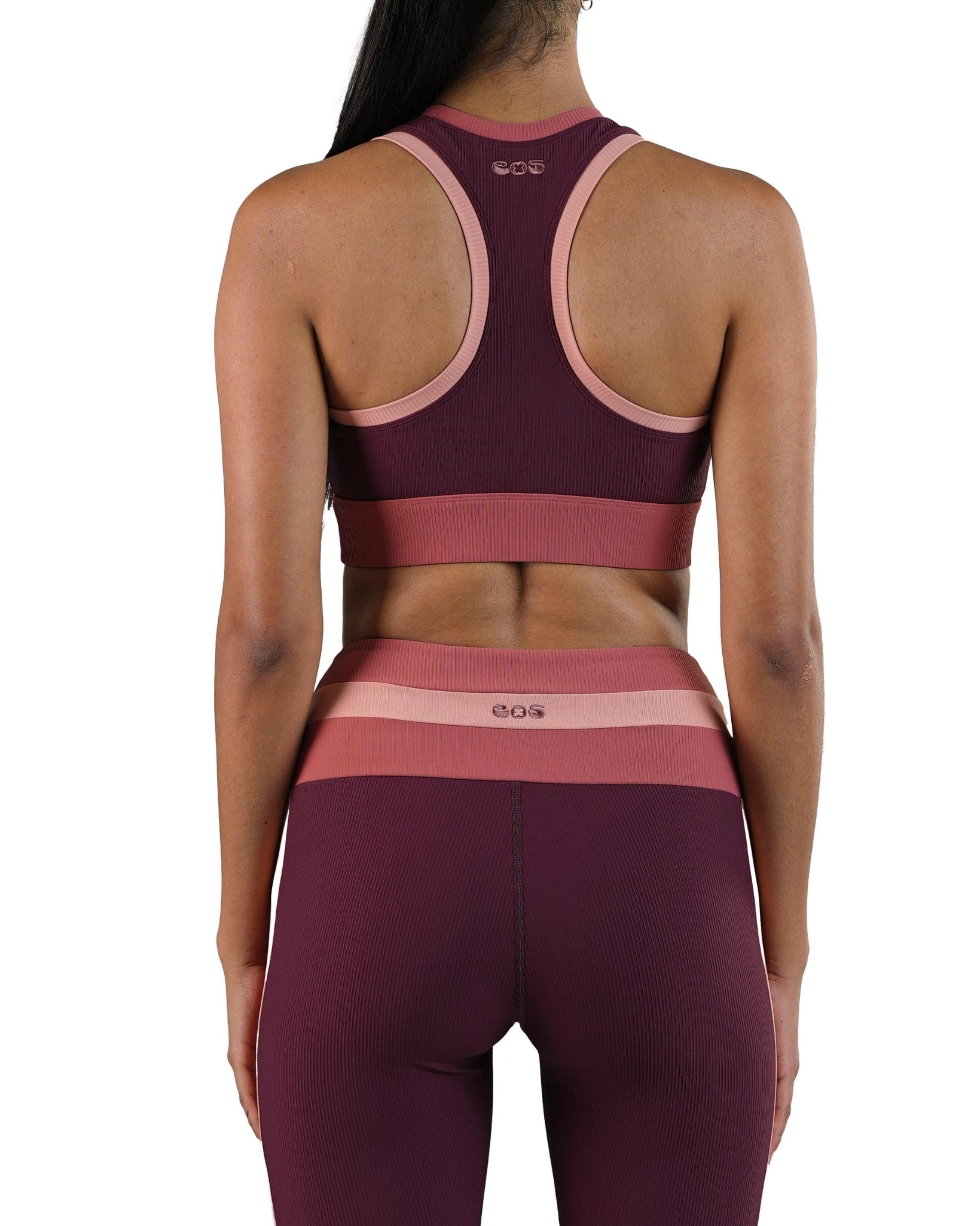 Maroon and pink sports bra and leggings set on a white background
