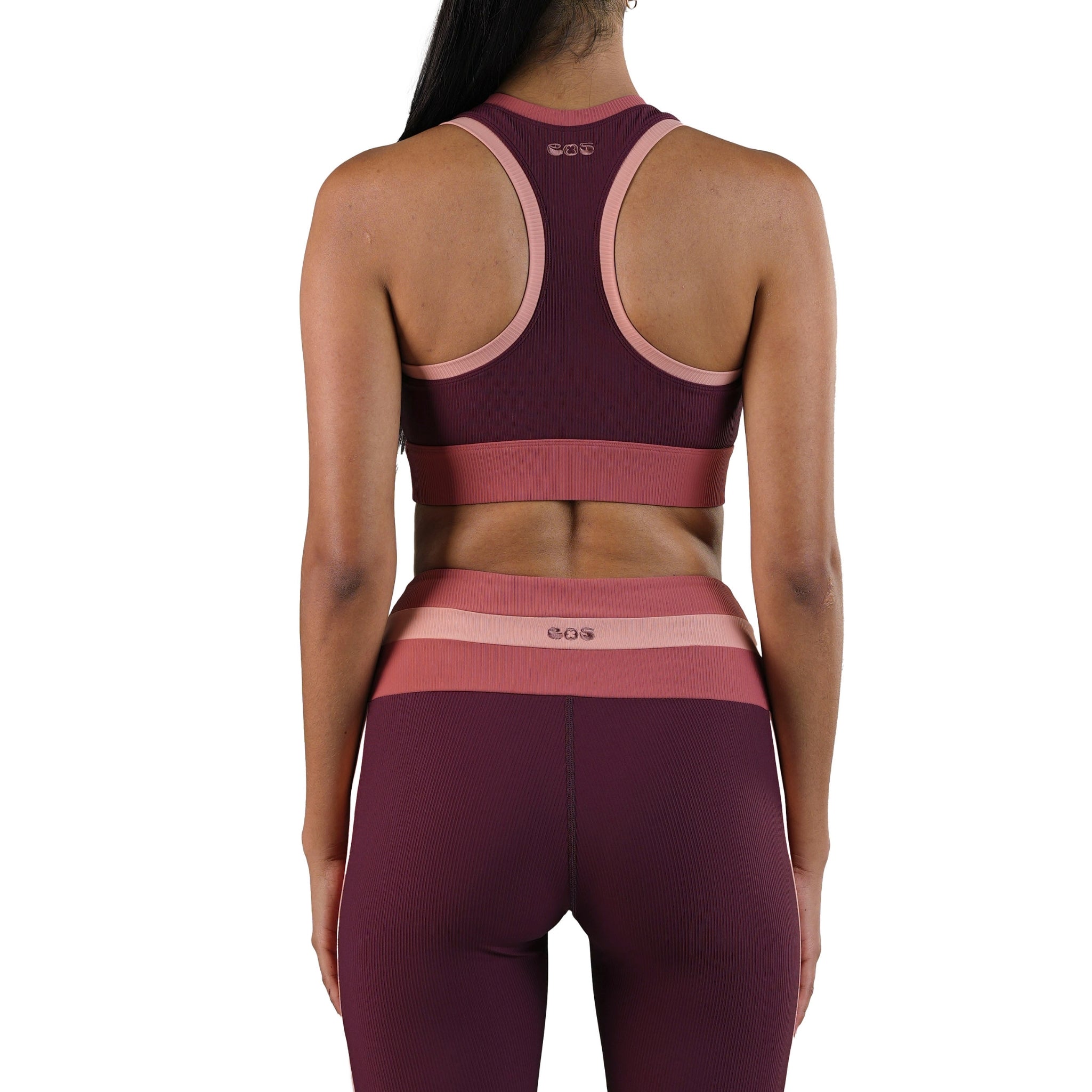 Maroon and pink sports bra and leggings set on a white background