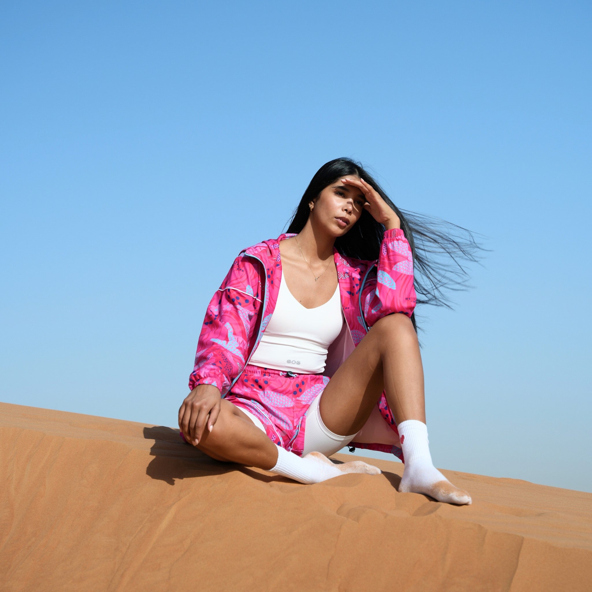 Model in a pair of pink floral running shorts and jacket.