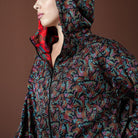 Person wearing a colorful patterned jacket with a hood on a brown background