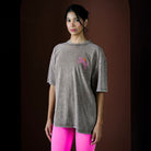 Woman wearing a gray t-shirt with a colorful design on a dark background