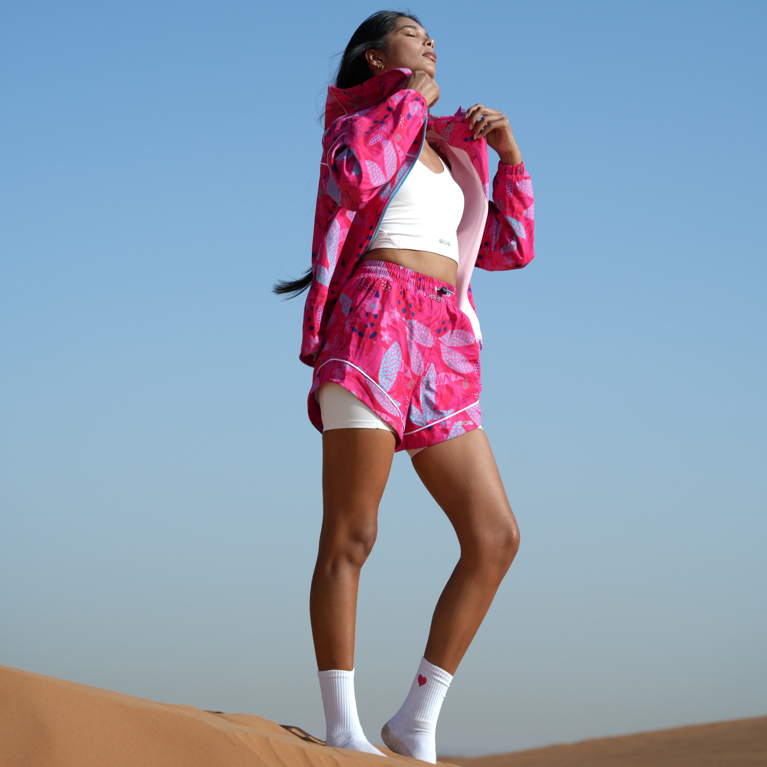 Model in a pair of pink floral running shorts and jacket.